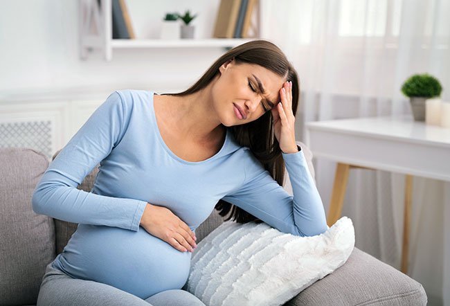 Why does a woman experience headache during and after pregnancy?